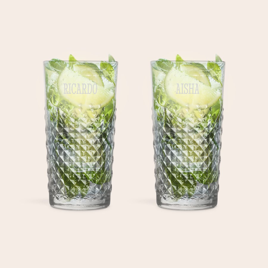 Two personalised engraved mojito glasses filled with mojitos, displaying the names Ricardo and Aisha