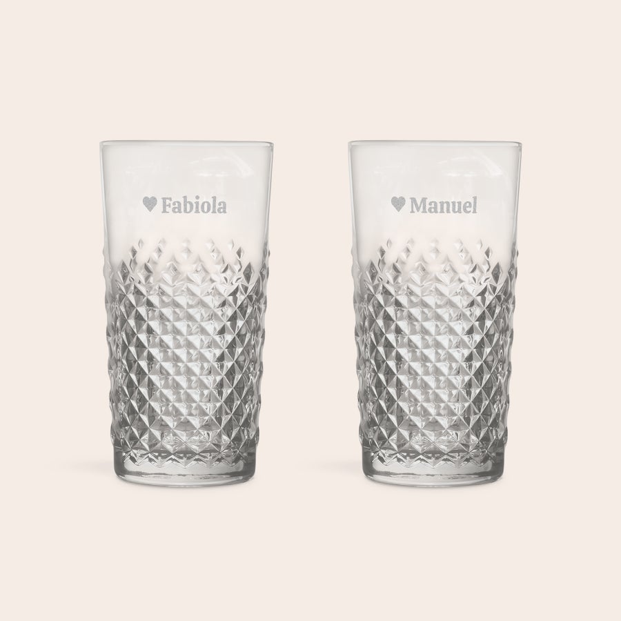 Engraved cocktail glass - Mojito Two personalized engraved mojito glasses with diamond patterns. One glass has "Fabiola" with a heart, and the other has "Manuel" with a heart, both engraved.