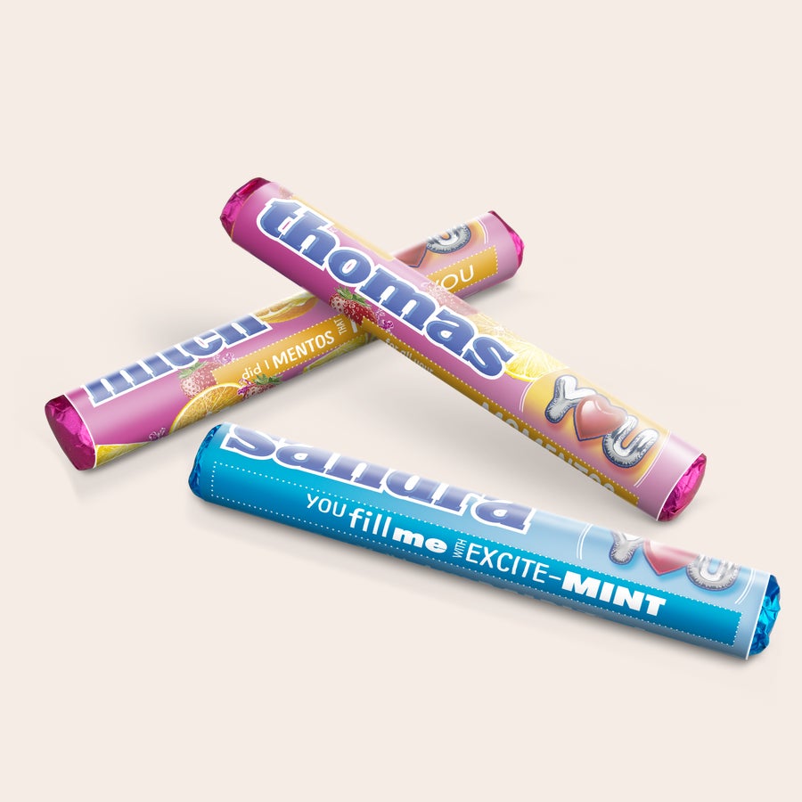 Two personalized Mentos rolls with text and fruit design, one with "Thomas" and one with "Sandra", ideal for a personalized Mentos gift box.