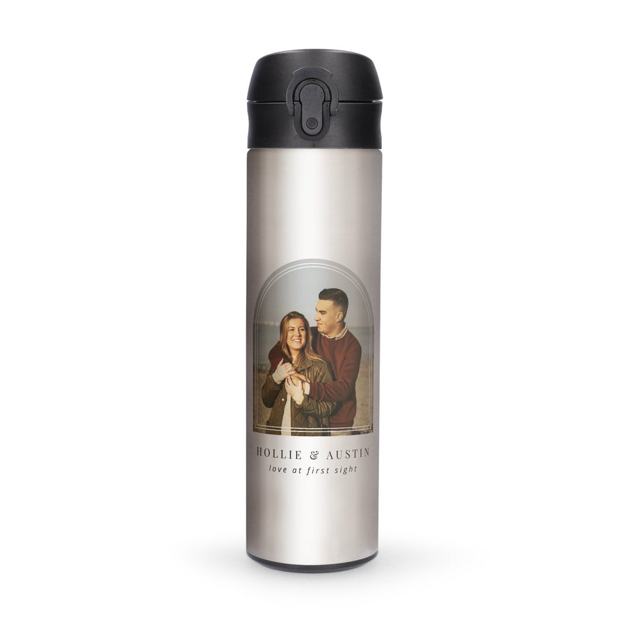 A personalized metal water bottle with a photo of a couple printed on it and the names Hollie & Austin with the text love at first sight.